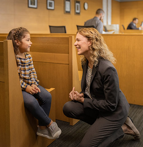 A CASA volunteer with her advocacy child in a courtroom