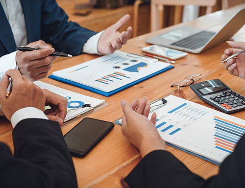 a board room meeting table with financial documents