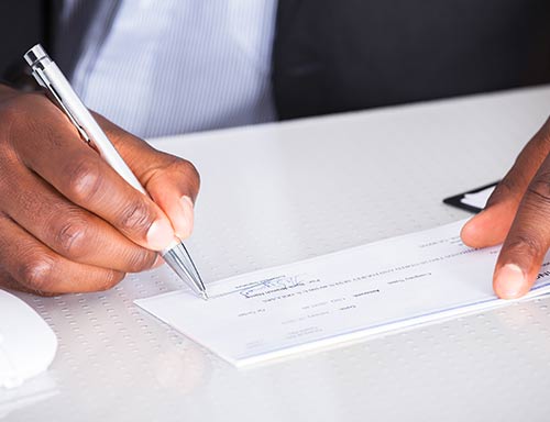 a man making a donation by writing a check